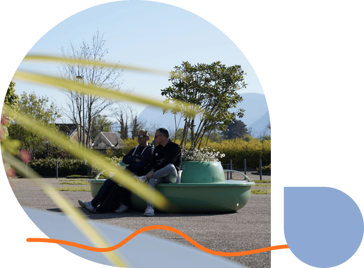 Deux hommes assis sur un meuble urbain Rainbeau.